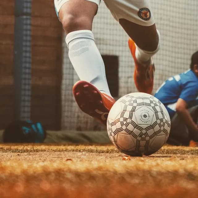 palla da calcio che viene calciata da un giocatore